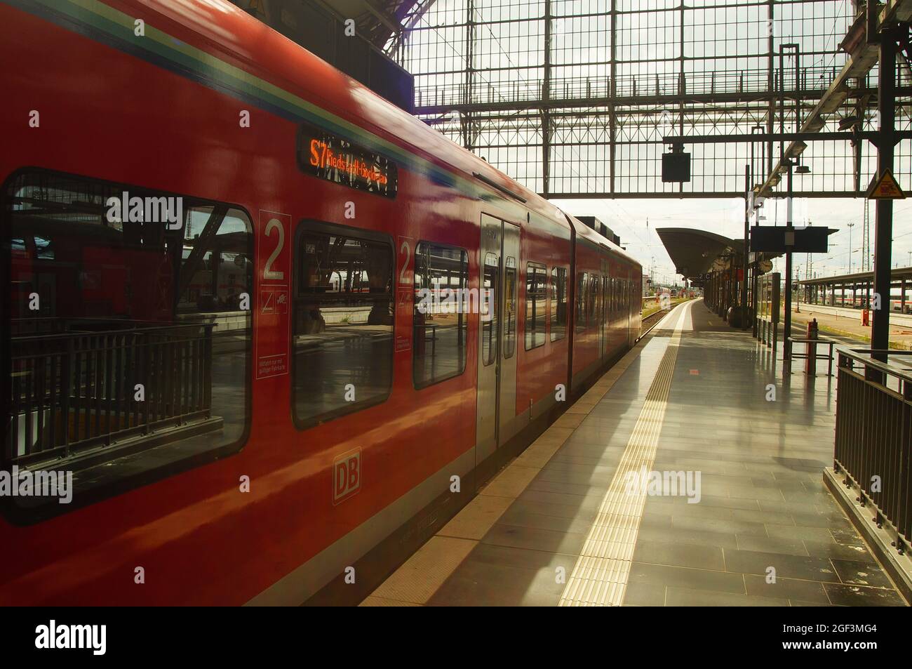 FRANKFURT, GERMANY - Aug 20, 2021: An S-Bahn at Frankfurt Central Station at the platform ready for departure. Sunny backlight with reflections. Stock Photo