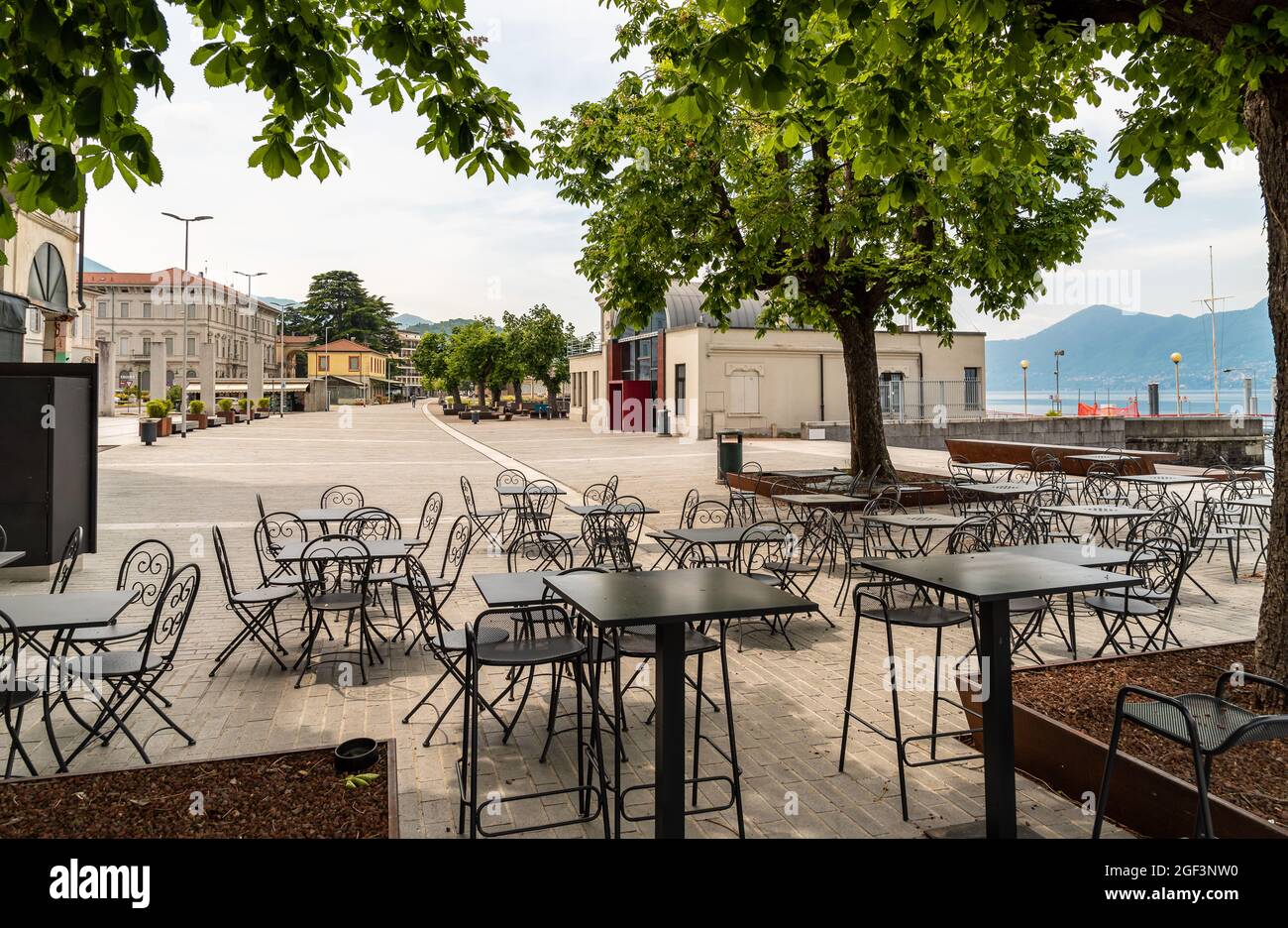 Tables and chairs of street cafe on lake Maggiore lakefront in Luino, Italy Stock Photo