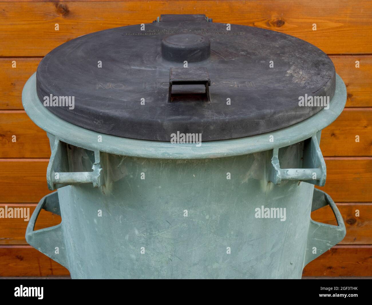 An old domestic household dustbin from 1973, with Property of City of Birmingham Salvage Department, in raised lettering on the lid. Stock Photo