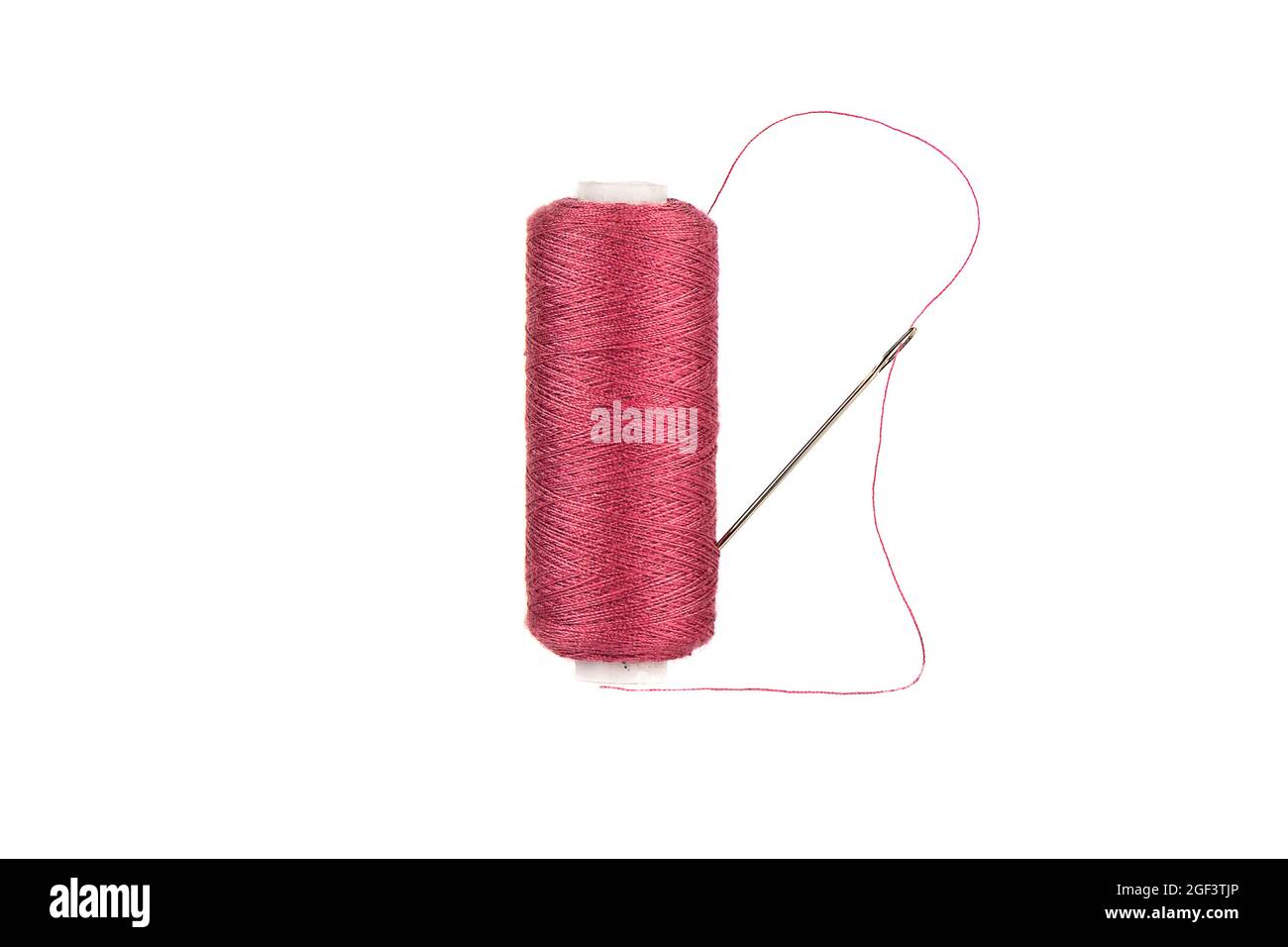 Needle and thread is stuck in an overlock spool with red threads. Copy ...