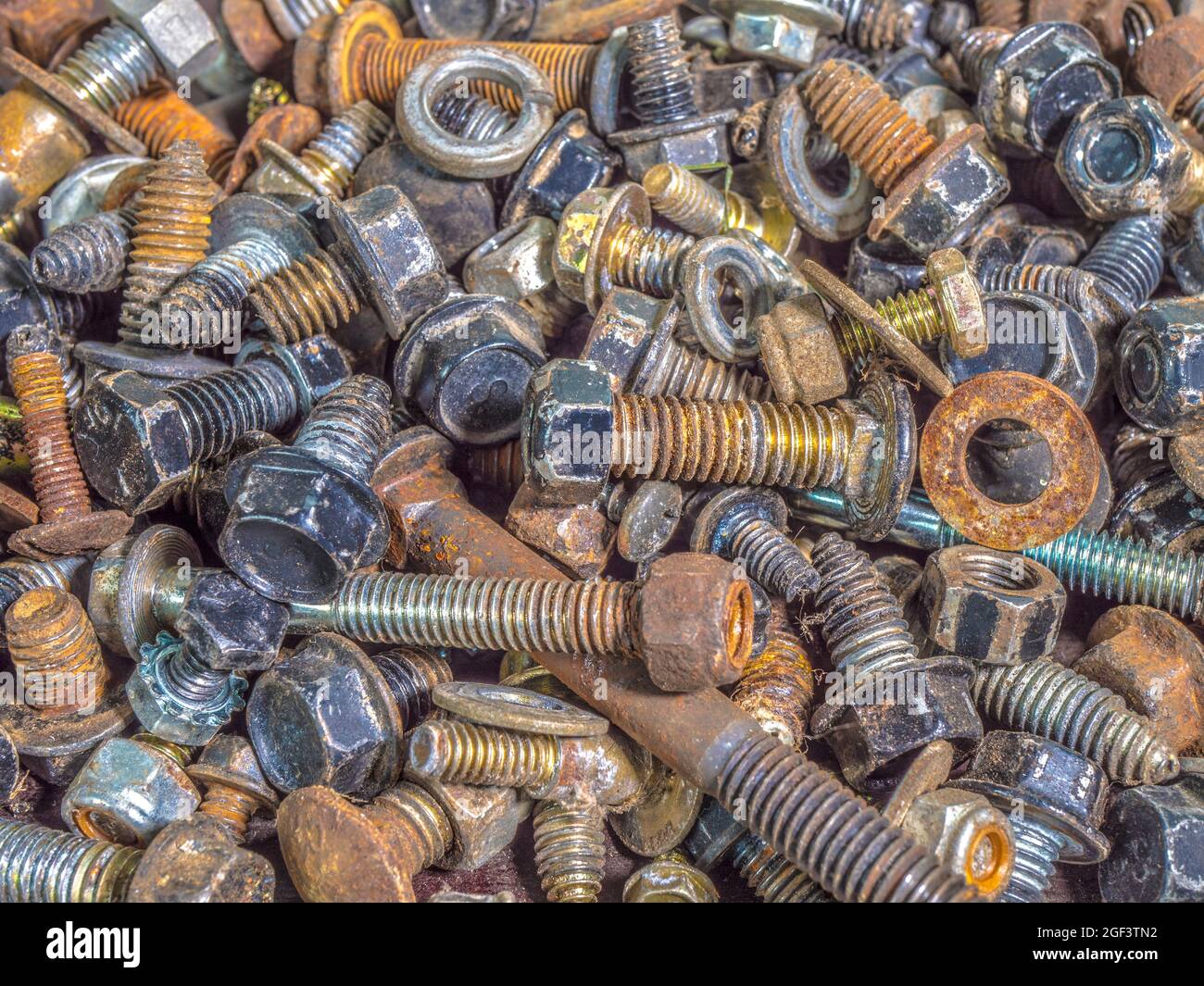Closeup POV overhead shot of a random assortment of used metal bolts, washers and nuts. Stock Photo