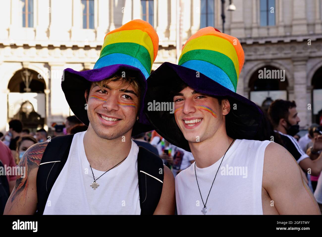Smiling gay male couple wearing a hat. Gay Pride Parade. LGBT community. Rome, Italy Stock Photo