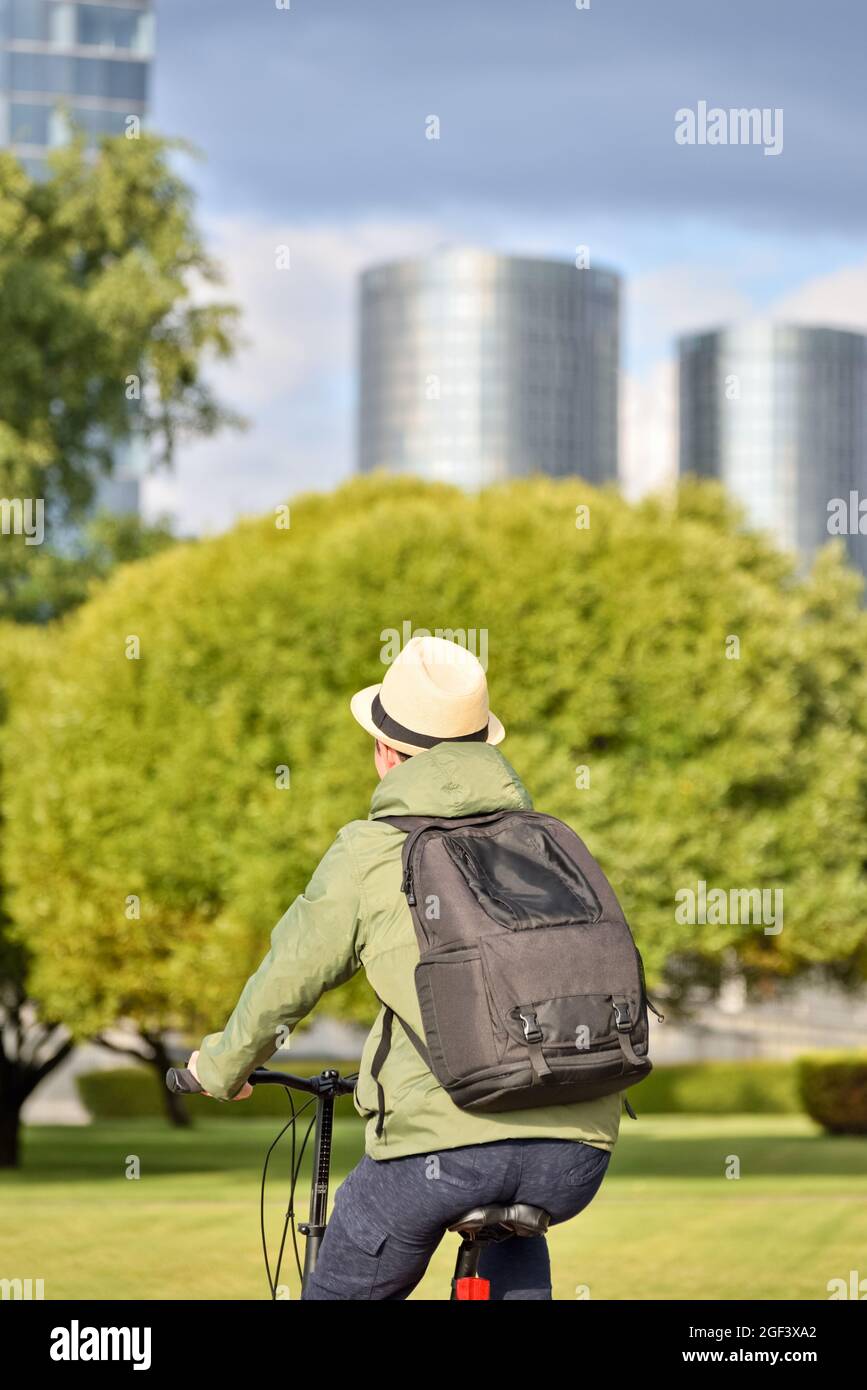 Man with backpack, cyclist on a bicycle while biking around the city. A