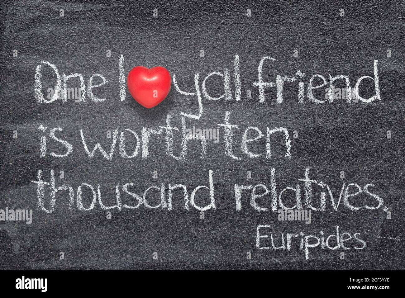 One loyal friend is worth ten thousand relatives - quote of ancient Greek philosopher Plato written on chalkboard with red heart instead of O Stock Photo
