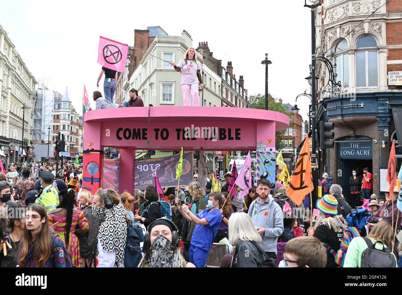 London, UK. 23 August 2021. Extinction Rebellion starts the two weeks of 'The Impossible Rebellion' in central London. Protesters blocked a junction in Covent Garden with a giant pink table. Credit: Andrea Domeniconi/Alamy Live News Stock Photo