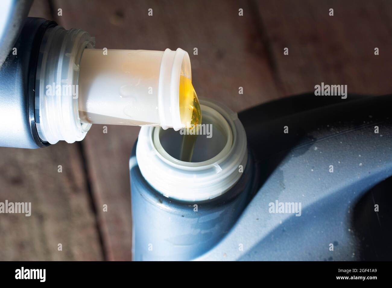 Motor pouring engine oil from plastic container. Refueling engine motor