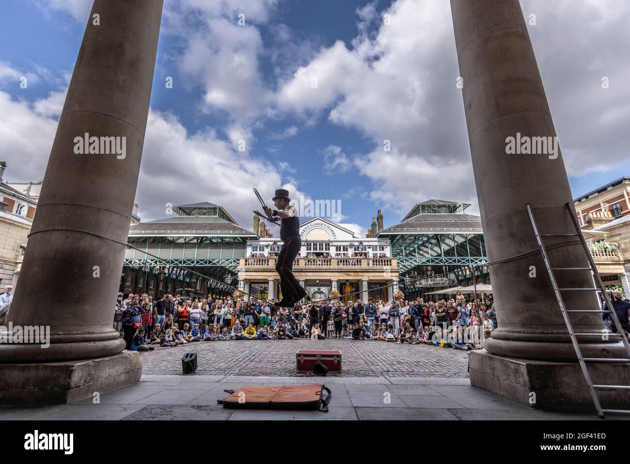 A street entertainer enjoys performing back in front of large crowds at Covent Garden Piazza, Central London, England, UK Stock Photo