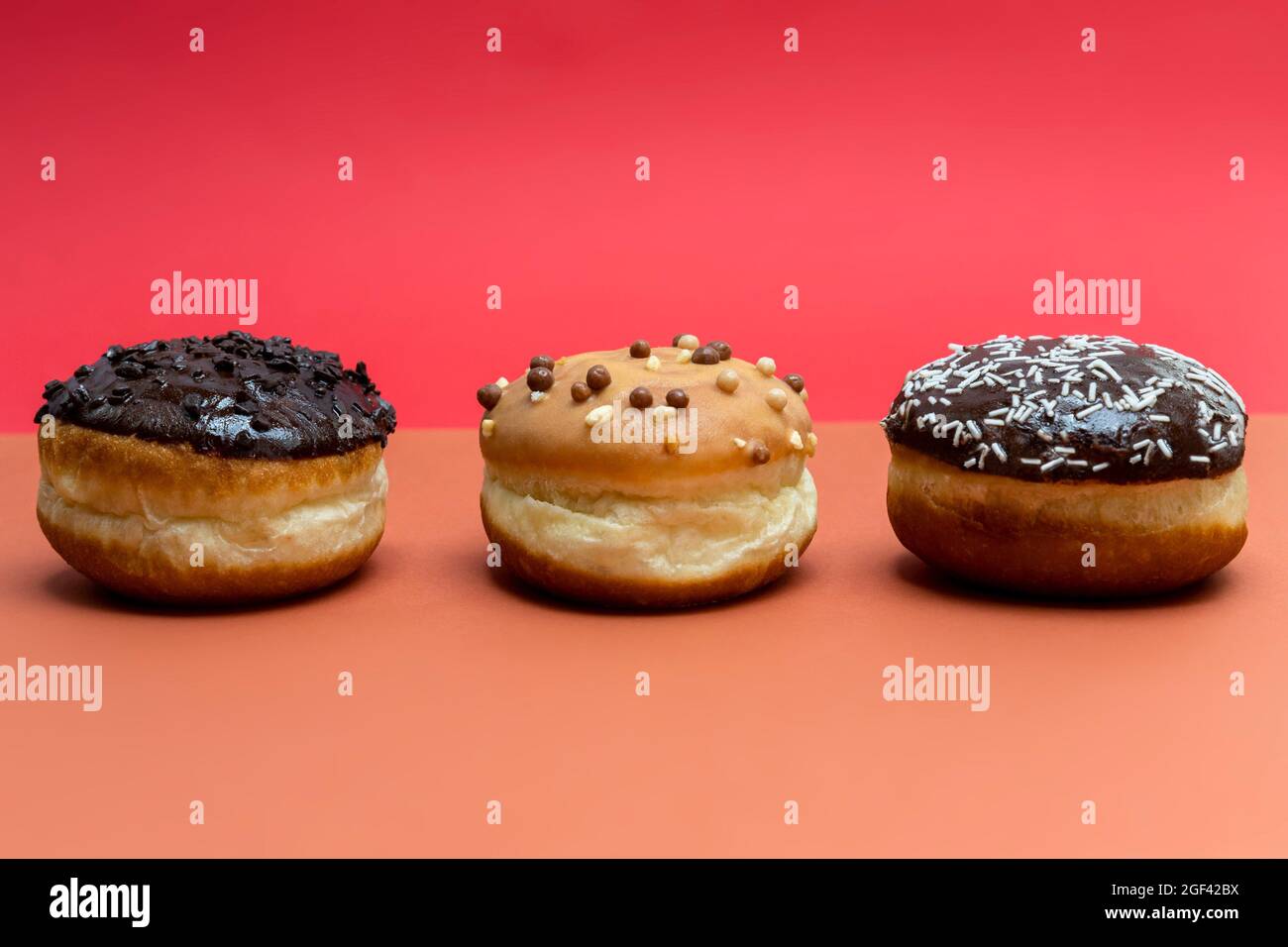 Delicious glazed chocolate donuts on vibrant background Stock Photo Alamy