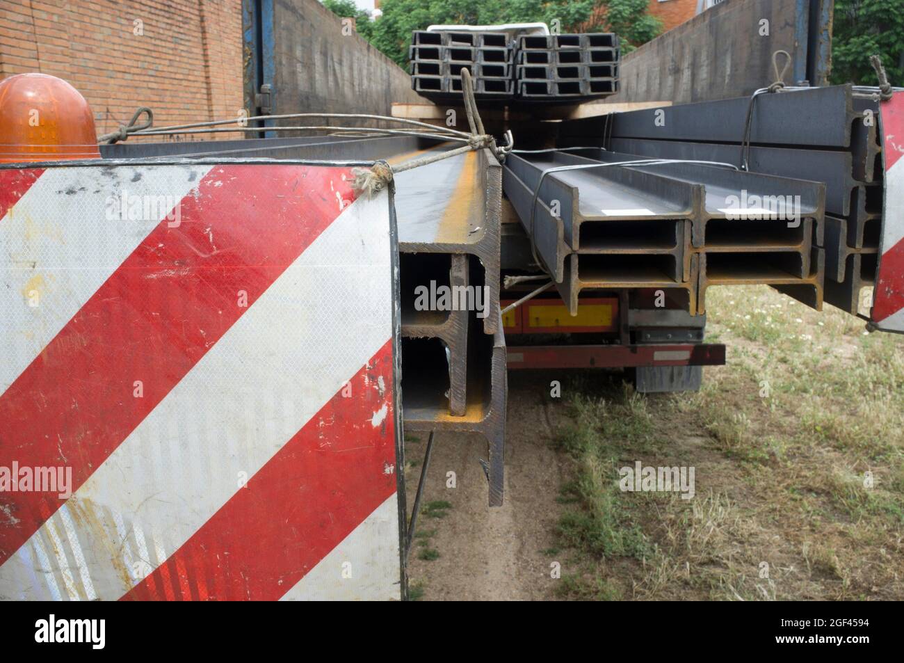 Building materials truck loaded with steel beams. Oversize load length restrictions concept. Stock Photo