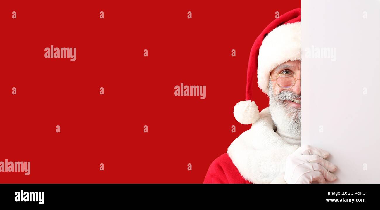 Happy Santa Claus with blank poster on color background with space for ...