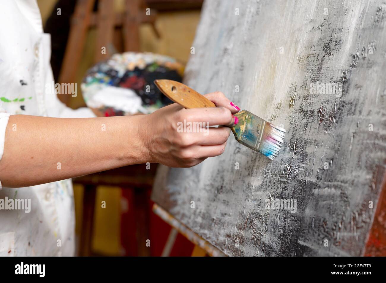 Close-up of an unrecognizable woman painter doing a brush stroke. High quality photo. Stock Photo