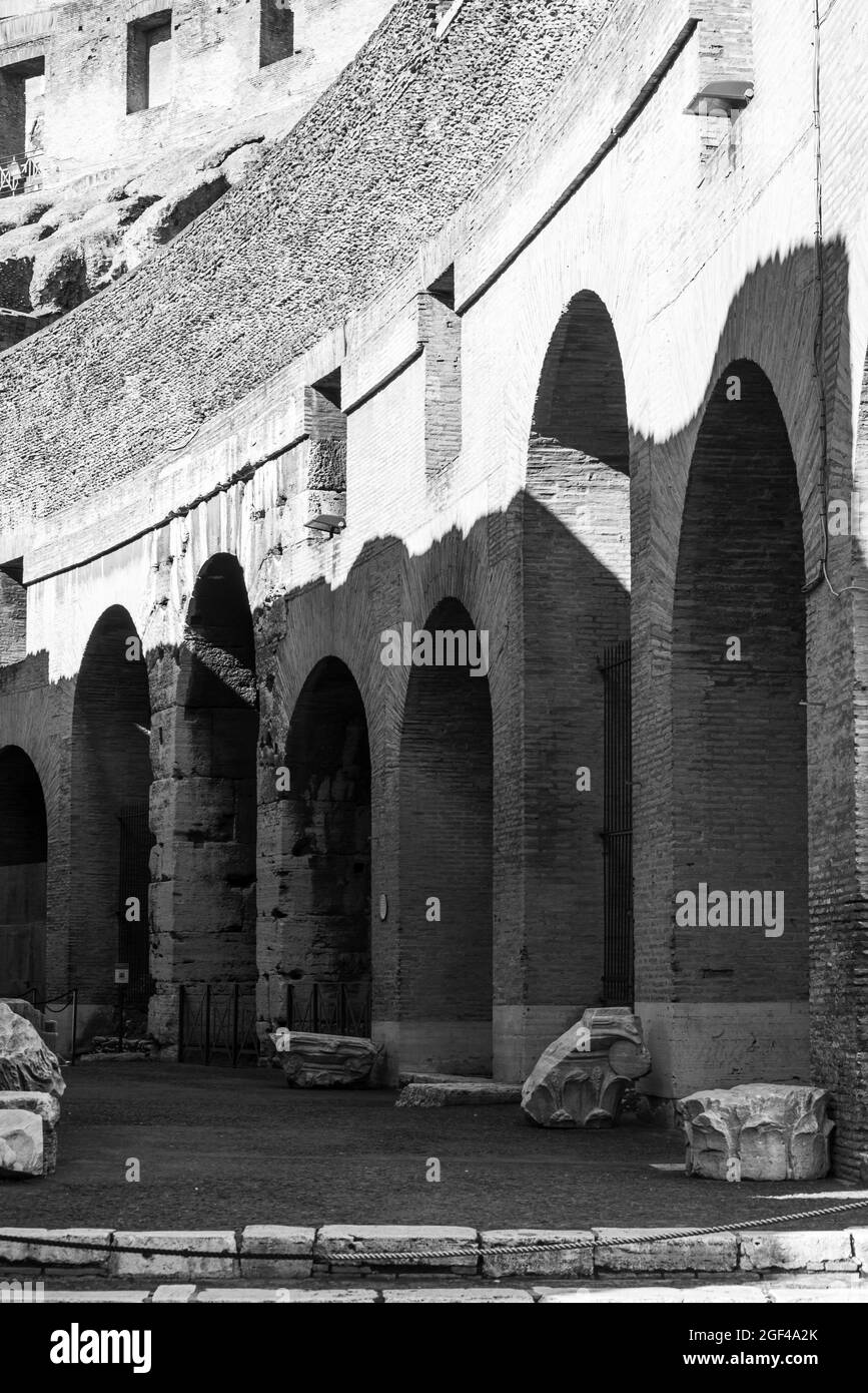 Black and white photo of sun light making shadows on ancient walls of Coliseum Stock Photo
