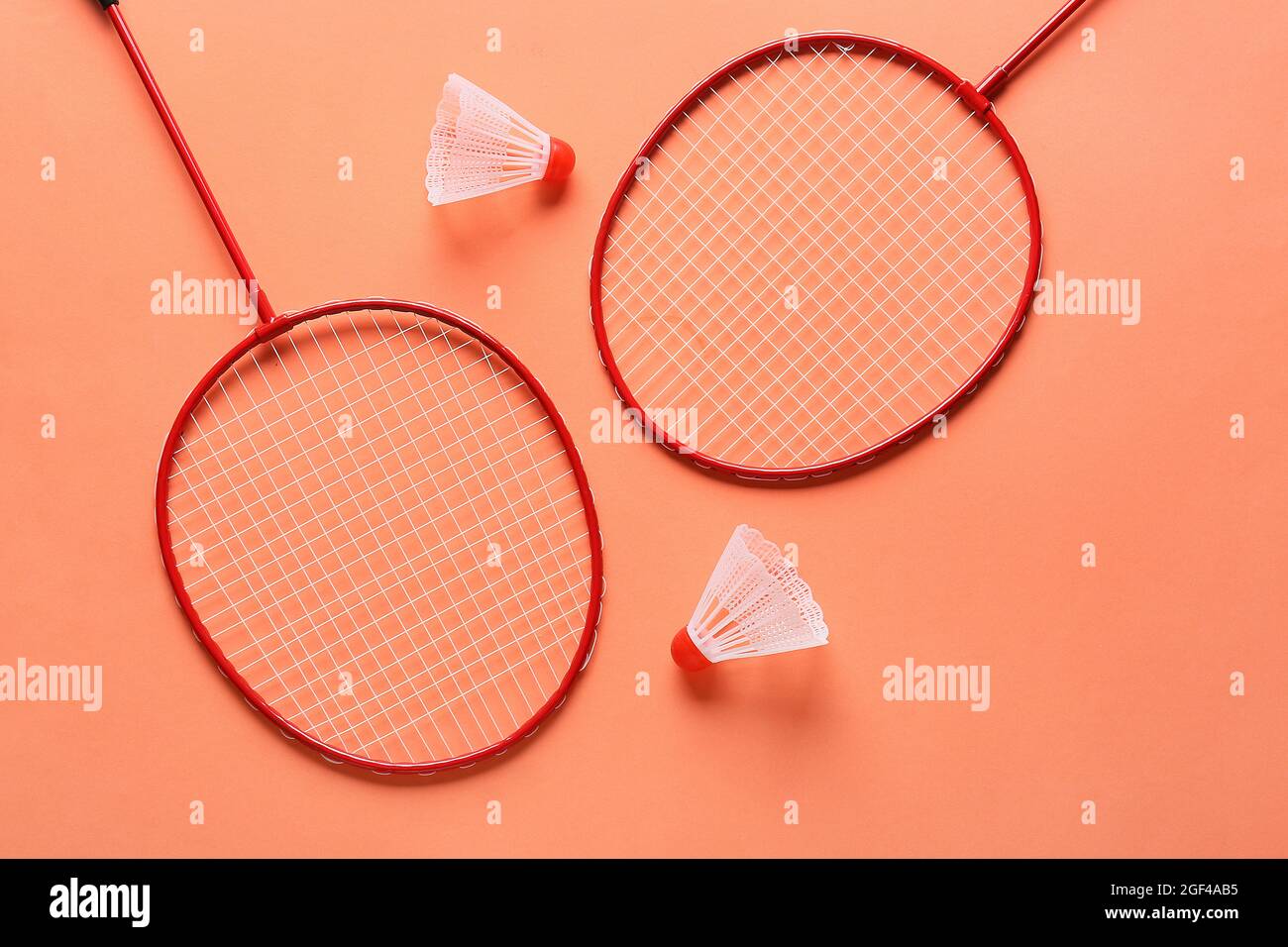 Badminton rackets and shuttlecocks on color background Stock Photo