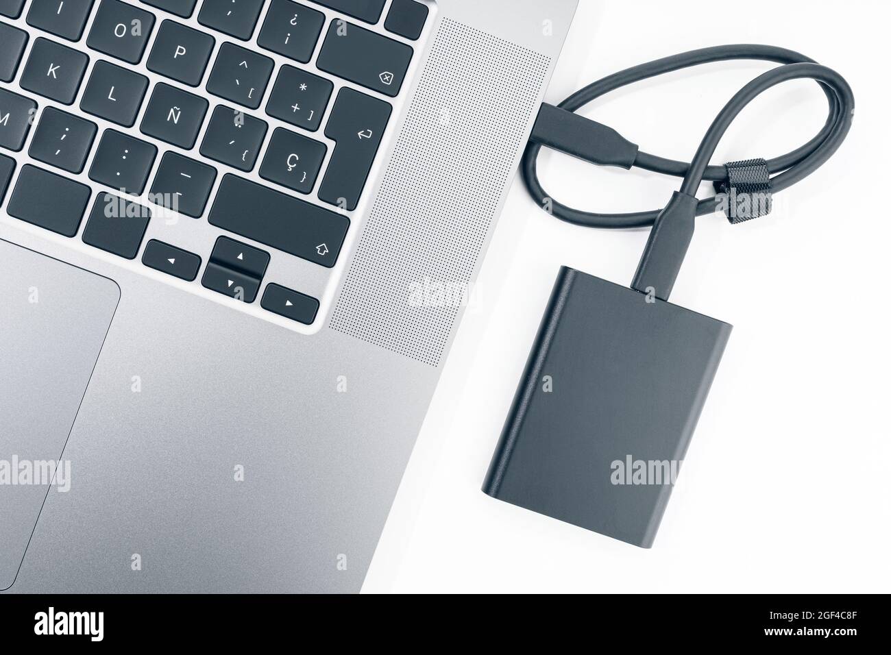 External hard disk connected to a modern laptop computer. Top view Stock Photo