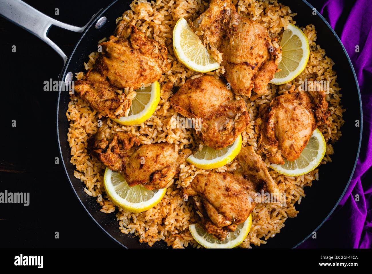 One Pan Spanish Chicken and Rice in a Skillet: Chicken thighs and rice seasoned with smoked paprika, garlic, and other spices Stock Photo