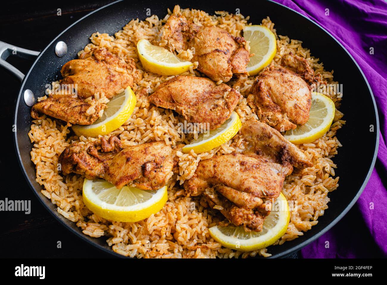 One Pan Spanish Chicken and Rice in a Skillet: Chicken thighs and rice seasoned with smoked paprika, garlic, and other spices Stock Photo