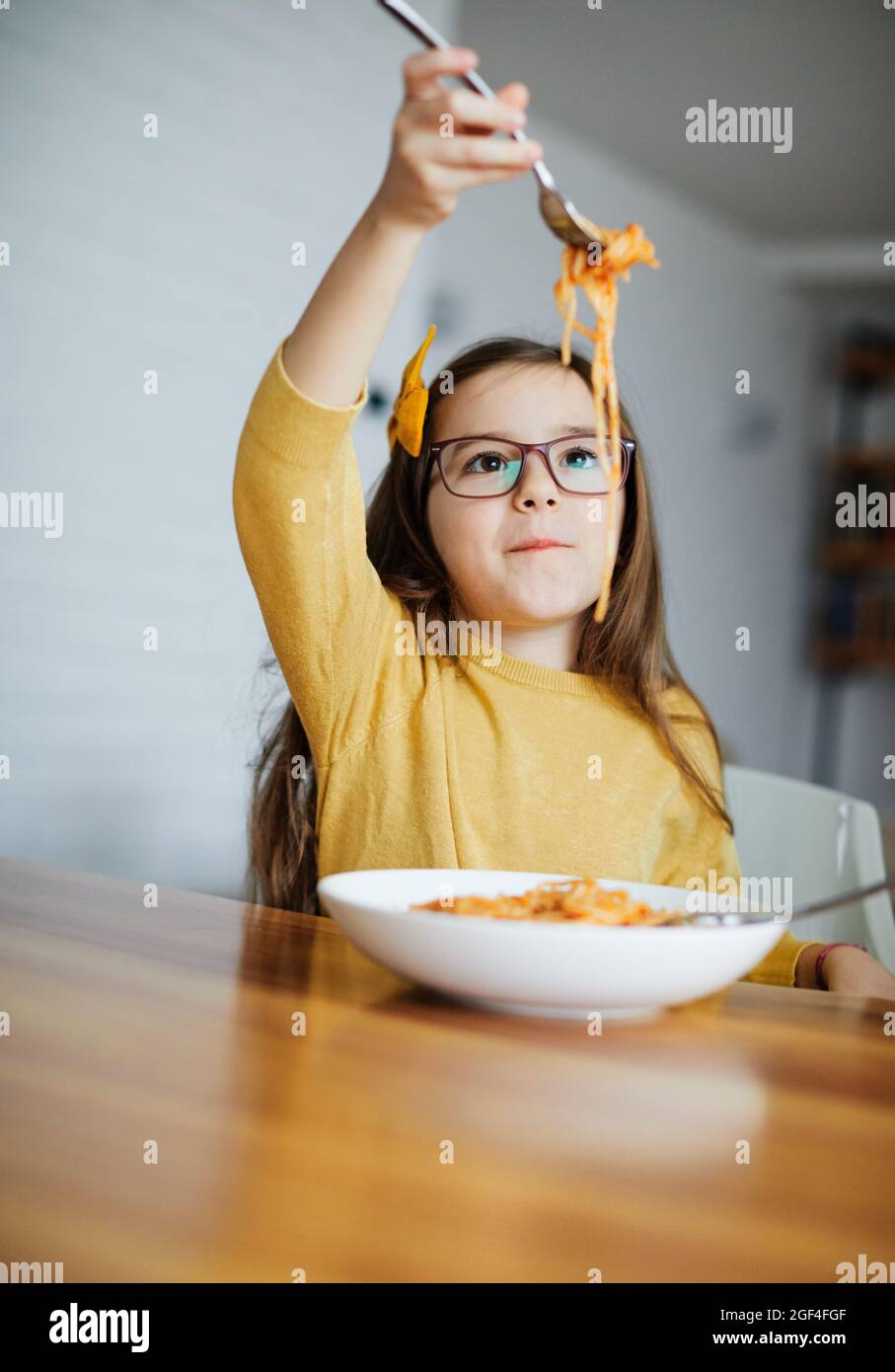 child daughter girl happy spaghetti pasta eating food meal lunch childhood Stock Photo