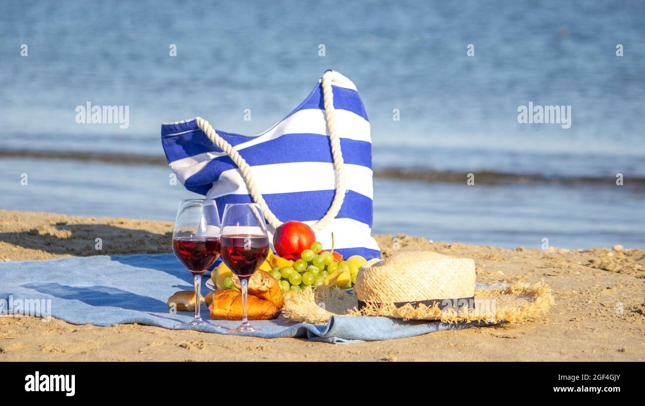 Picnic blanket, wine, fruit, beautiful sea beach Nature Selective focus