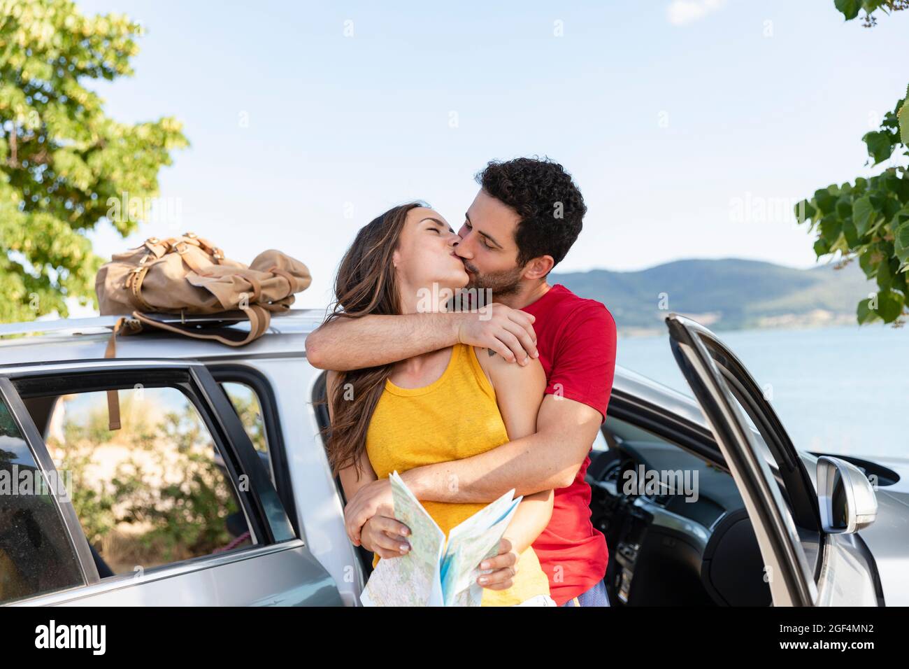 Couple kissing each other while standing by car Stock Photo