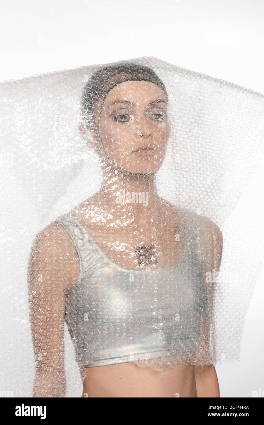 Cyborg woman covered with bubble wrap plastic against white background Stock Photo