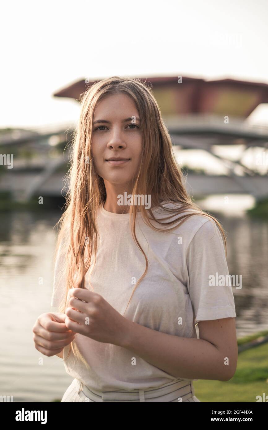 Close-up portrait of beautiful caucasian woman with blond hair walking  outdoors. Attractive Girl without Makeup in White t-shirt. Natural Skin  Beauty Stock Photo - Alamy, image size:866x1390