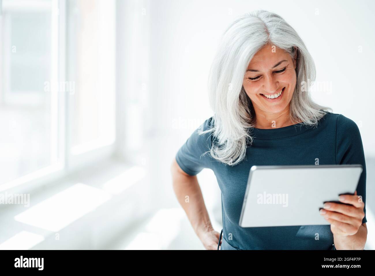 Smiling businesswoman using digital tablet at office Stock Photo
