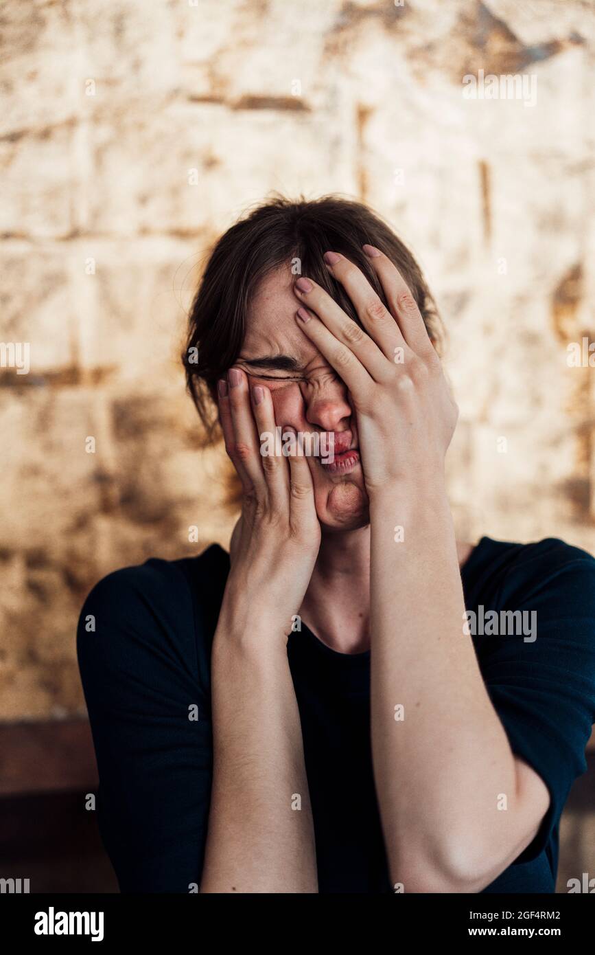 Frustrated woman covering face with hands Stock Photo