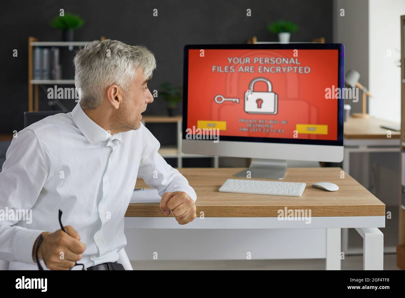 Man has computer security problems and receives a ransomware warning on the screen Stock Photo