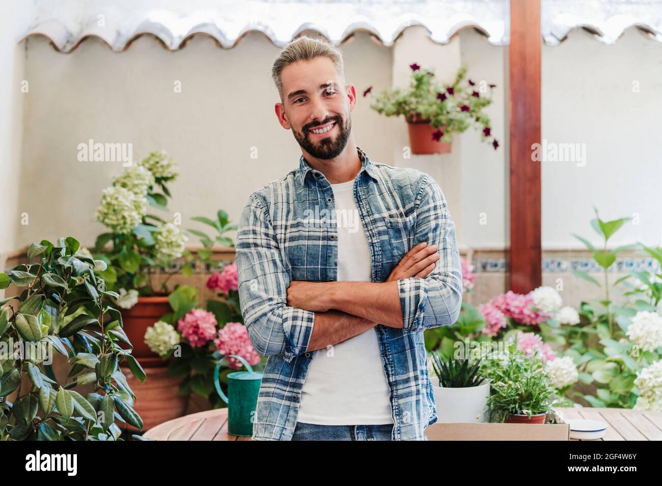 Handsome man with arms crossed standing at backyard Stock Photo