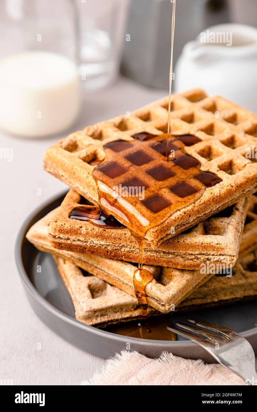Maple syrup pouring on stack of fresh waffles Stock Photo Alamy