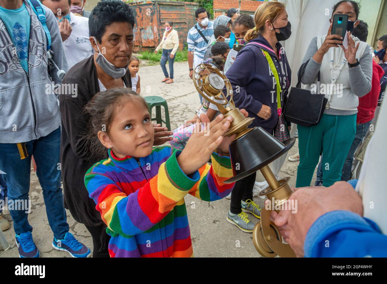 A girl touches with her hands the relic of Blessed Jose Gregorio Hernandez, for his blessing.  Relic of Blessed José Gregorio Hernández. Caracas, Vene Stock Photo