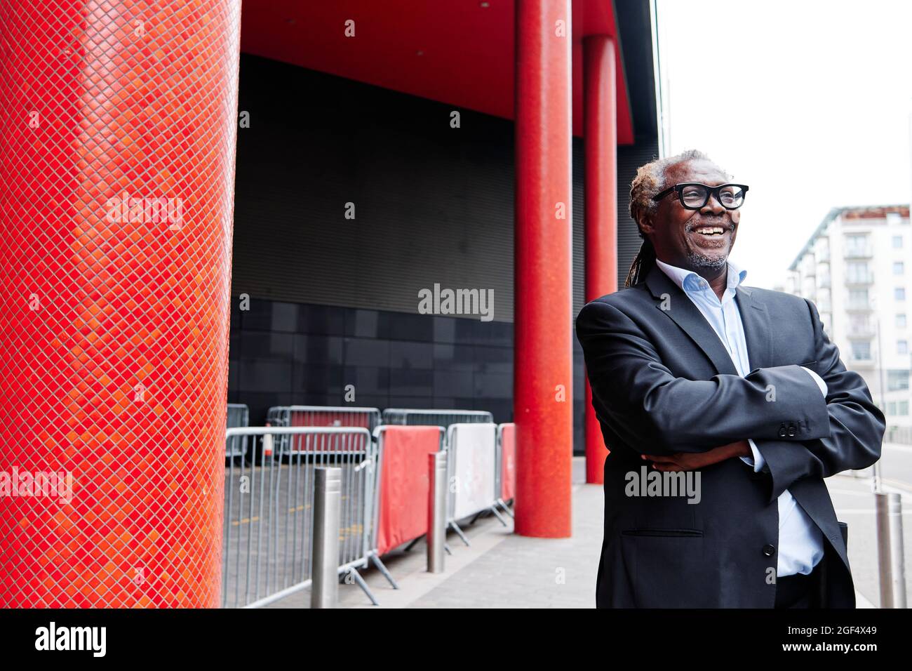 Happy businessman with arms crossed in front of building Stock Photo ...