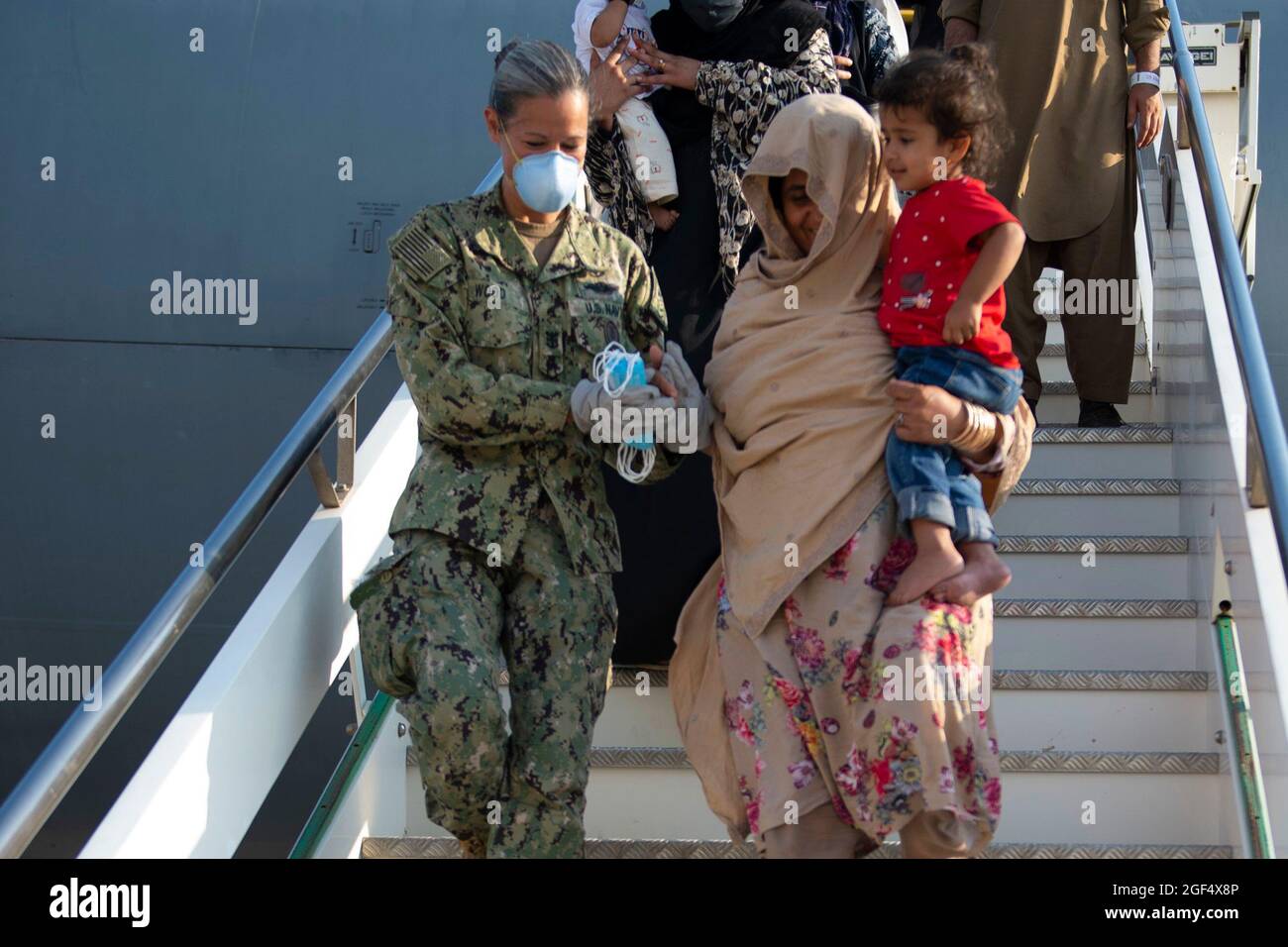 Naval Air Station Sigonella Command Master Chief Anna Wood assists an evacuee disembarking a US Air Force KC-10 Extender August 22, 2021. NAS Sigonella is currently supporting the Department of Defense mission to facilitate the safe departure and relocation of U.S. citizens, Special Immigration Visa recipients, and vulnerable Afghan populations from Afghanistan. Mandatory Credit: Kegan E. Kay/US Navy via CNP Stock Photo