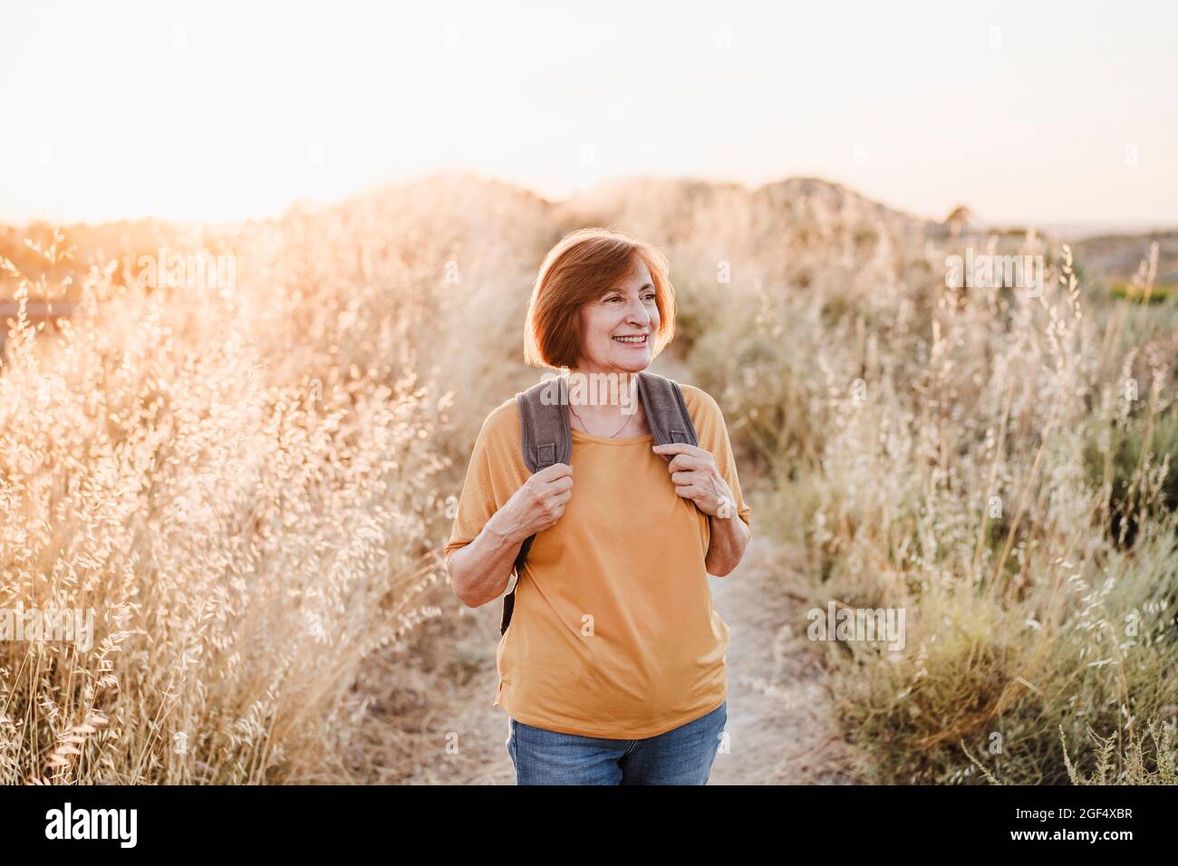 Smiling senior woman looking away while hiking Stock Photo