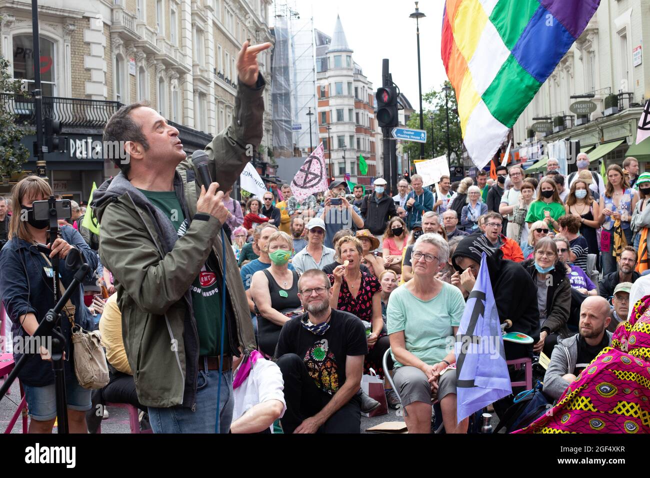 London, England, UK 23rd August 2021 Extinction Rebellions Impossible Rebellion begins in Trafalgar Square, marching towards the Strand, blocking the Long Acre and St Martins Lane intersection with a giant pink table and chairs, speakers including comedian Mark Thomas addressed the crowd assembled Credit: Denise Laura Baker/Alamy Live News Stock Photo