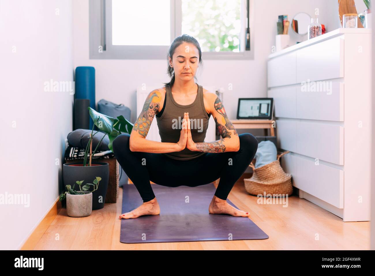 Young woman meditating while doing yoga at home Stock Photo - Alamy