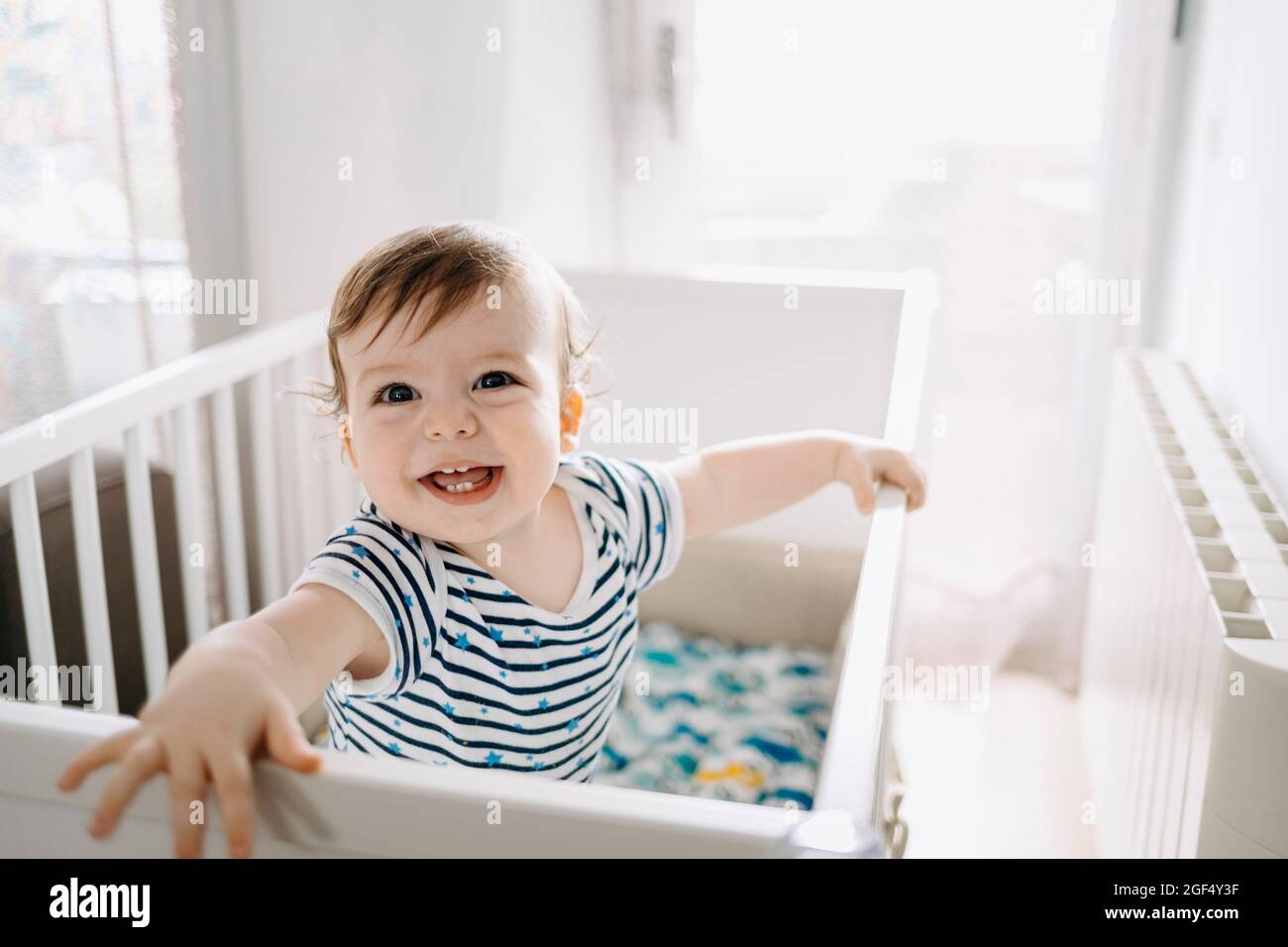 Happy baby boy in crib at home Stock Photo Alamy