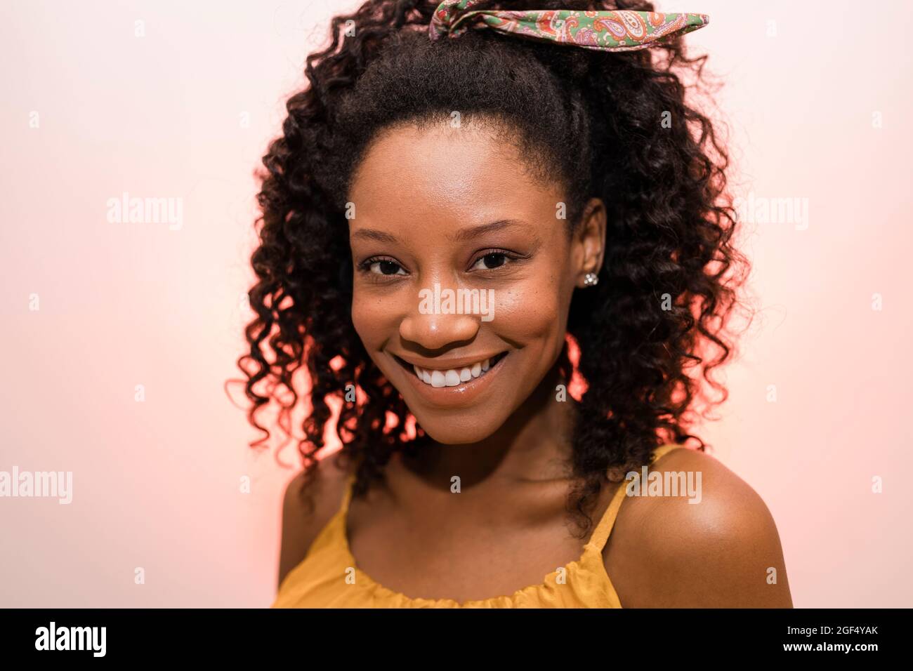 Young woman with curly hair smiling against white background Stock ...