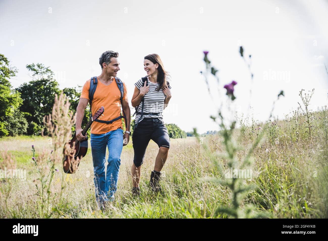 Smiling couple hiking together on grass Stock Photo