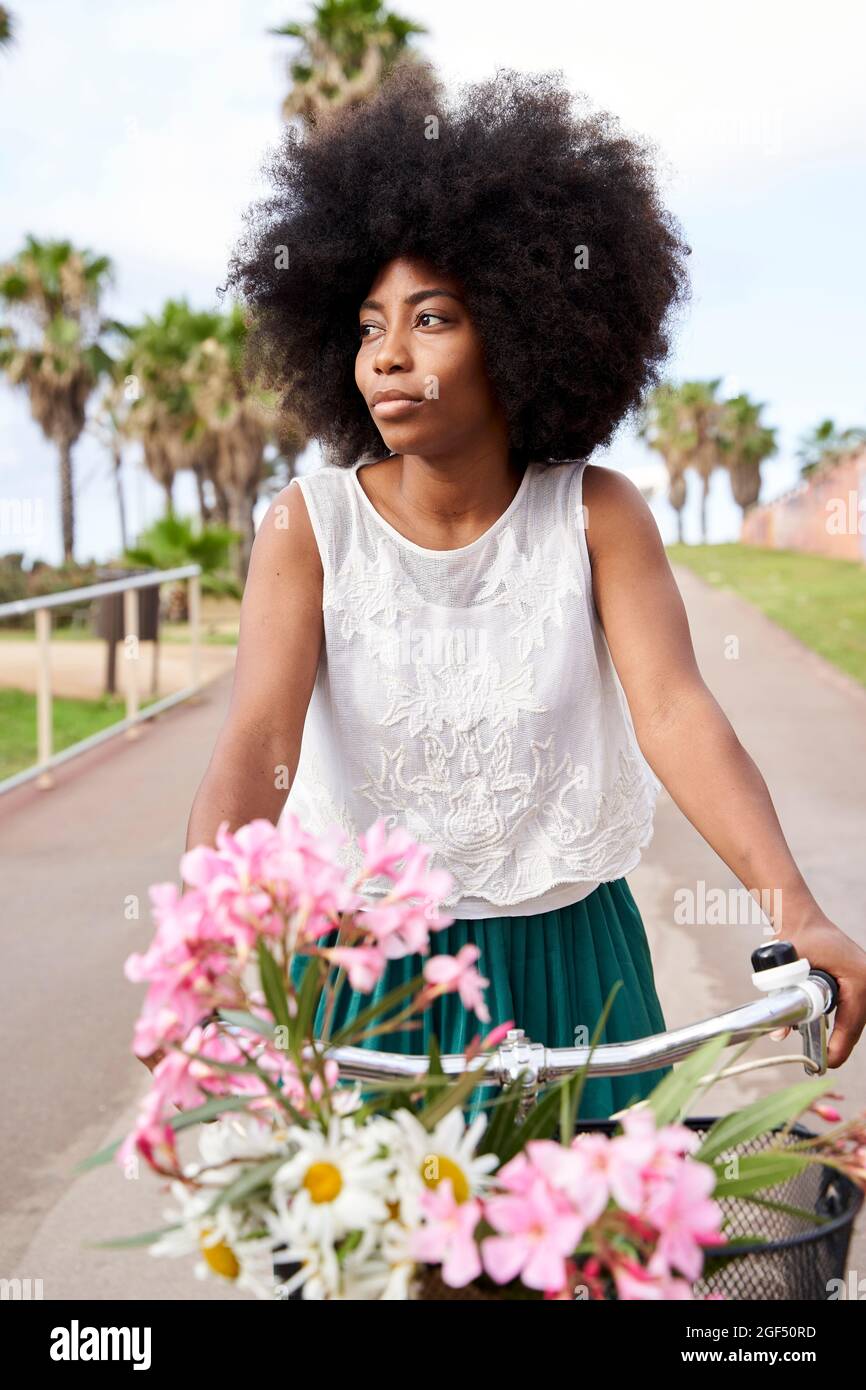 Woman looking away while riding bicycle on road Stock Photo