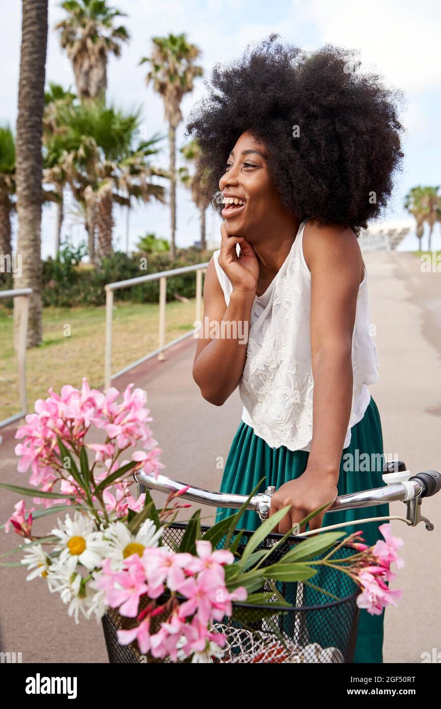 Happy woman with bicycle standing on road Stock Photo