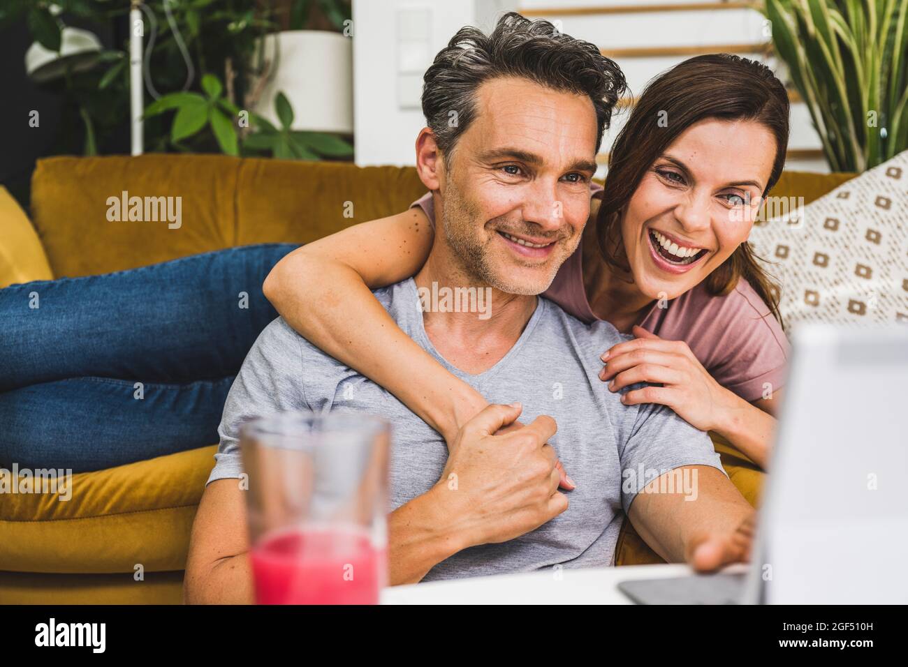 Happy couple using digital tablet at home Stock Photo