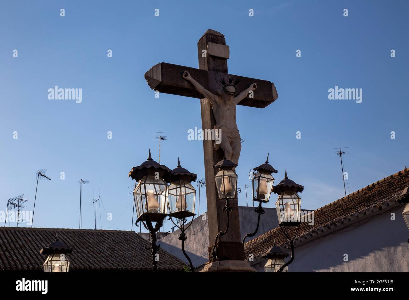 Girl contemplating the Christ of the Lanterns at sunset in the Plaza de Capuchinos in Cordoba Andalusia Spain Stock Photo