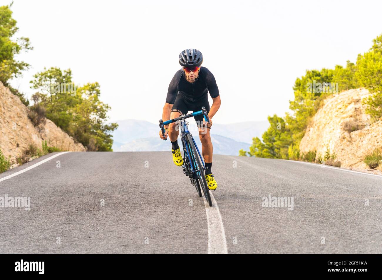Male sportsperson cycling on road Stock Photo