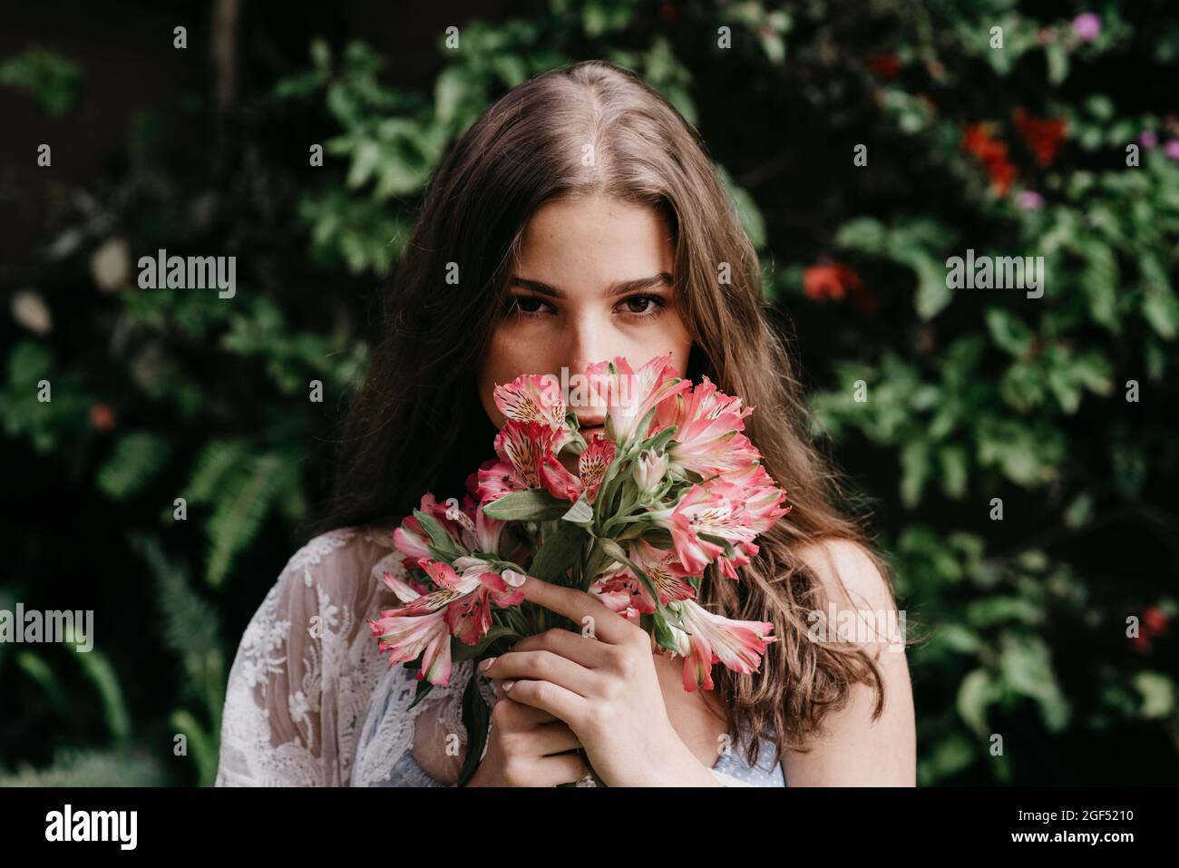 Young woman smelling fresh flowers Stock Photo