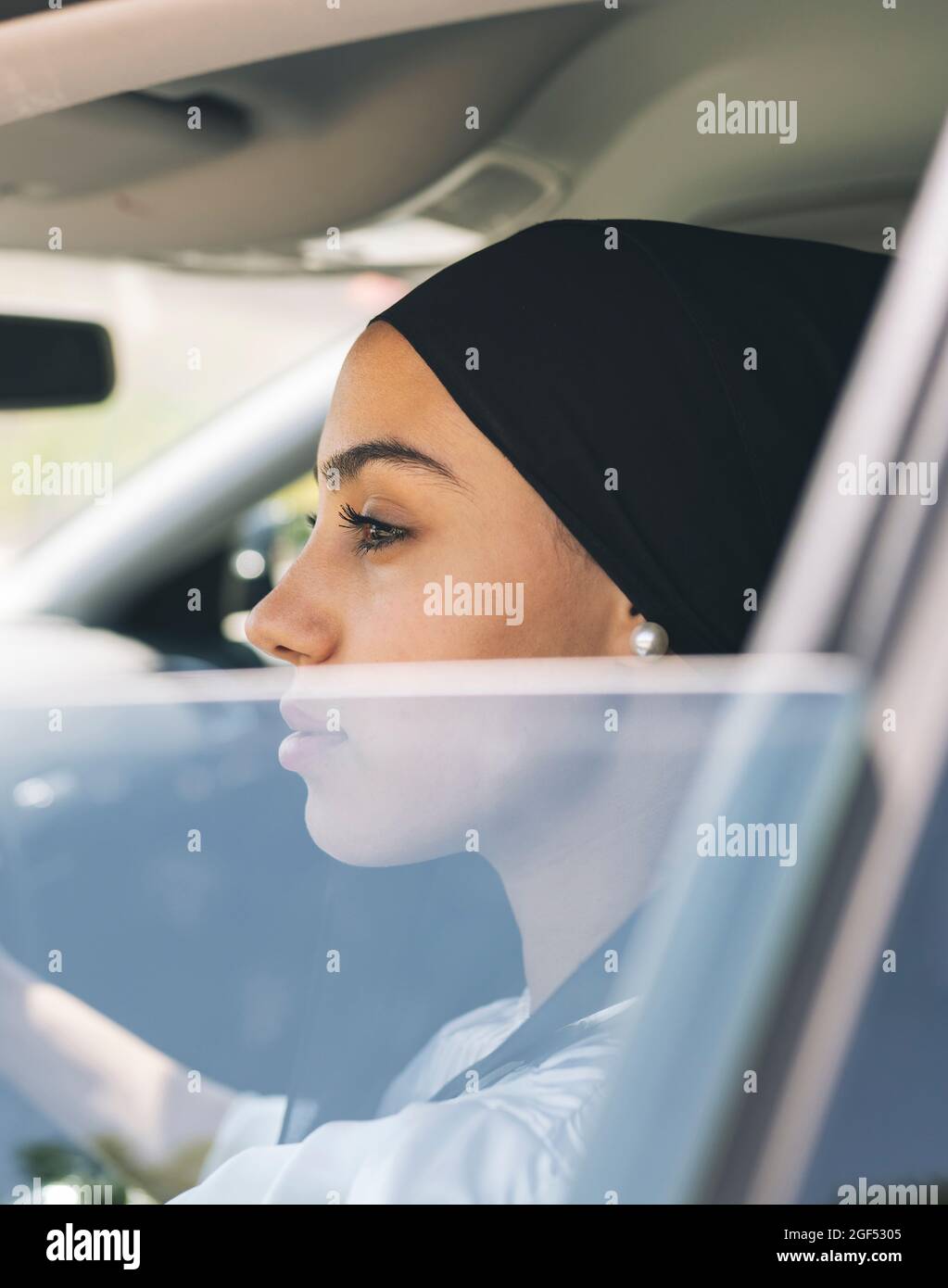 Woman looking through window while sitting in car Stock Photo