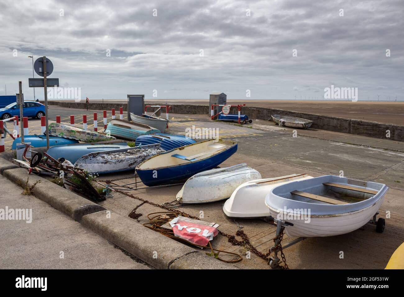 Meols, Wirral, UK: Boats chained up beside the slipway down to the beach. Stock Photo