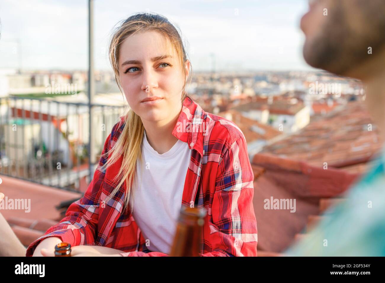 Young woman looking at male friend on rooftop Stock Photo