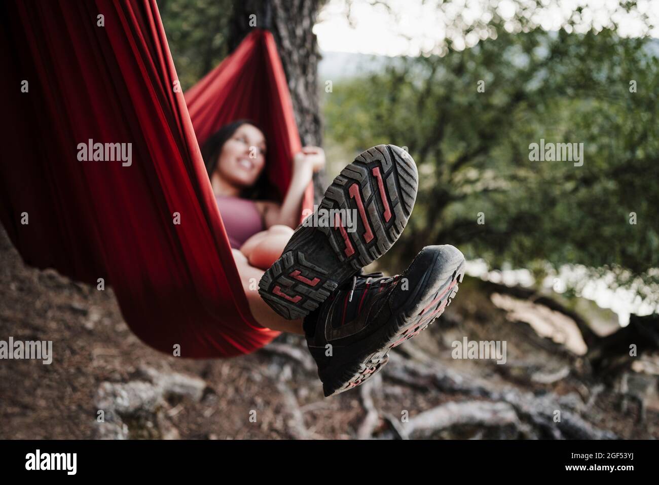 Woman relaxing on hammock in forest during vacation Stock Photo