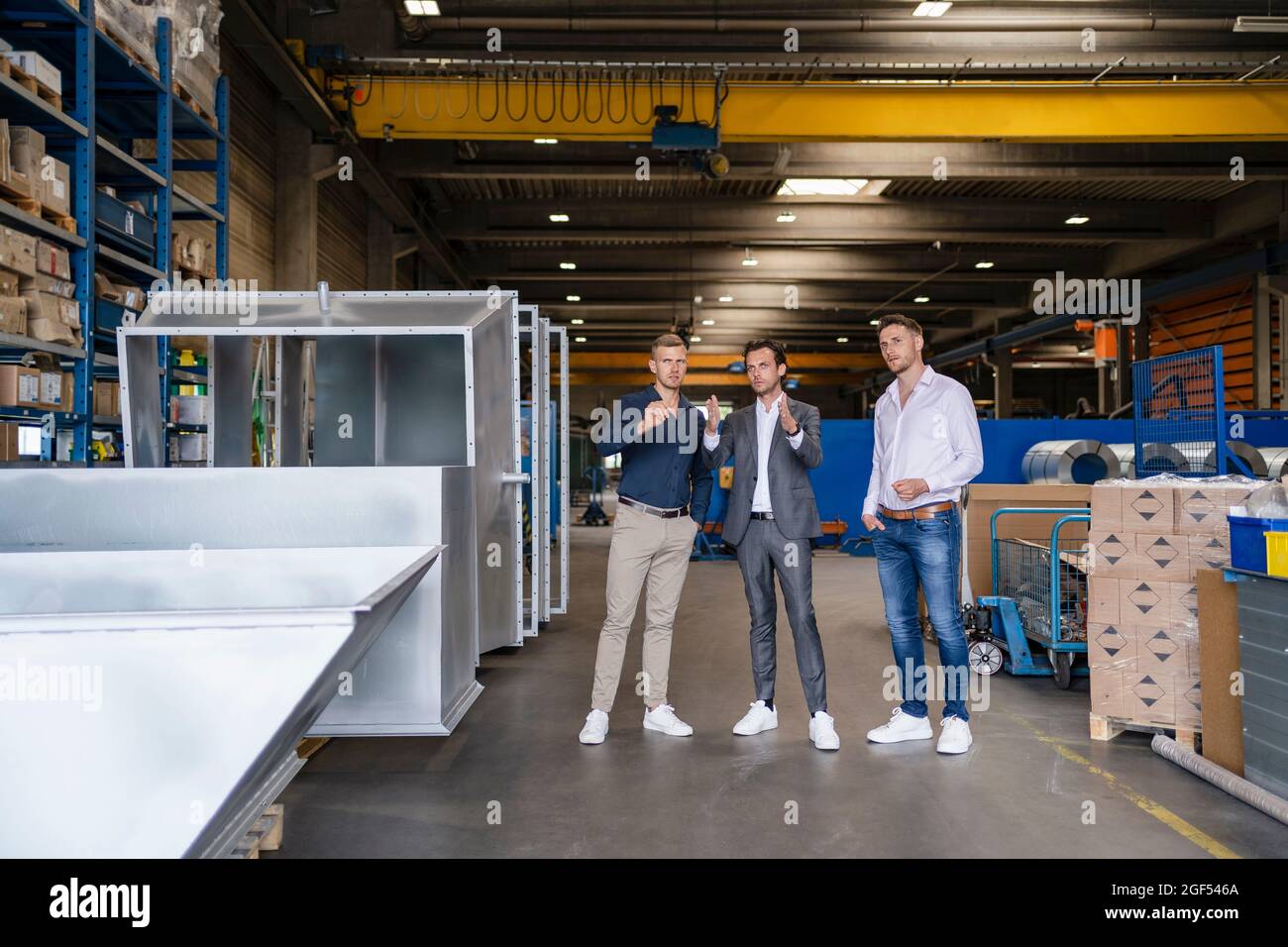 Businessman gesturing while explaining vision to colleagues at industry Stock Photo